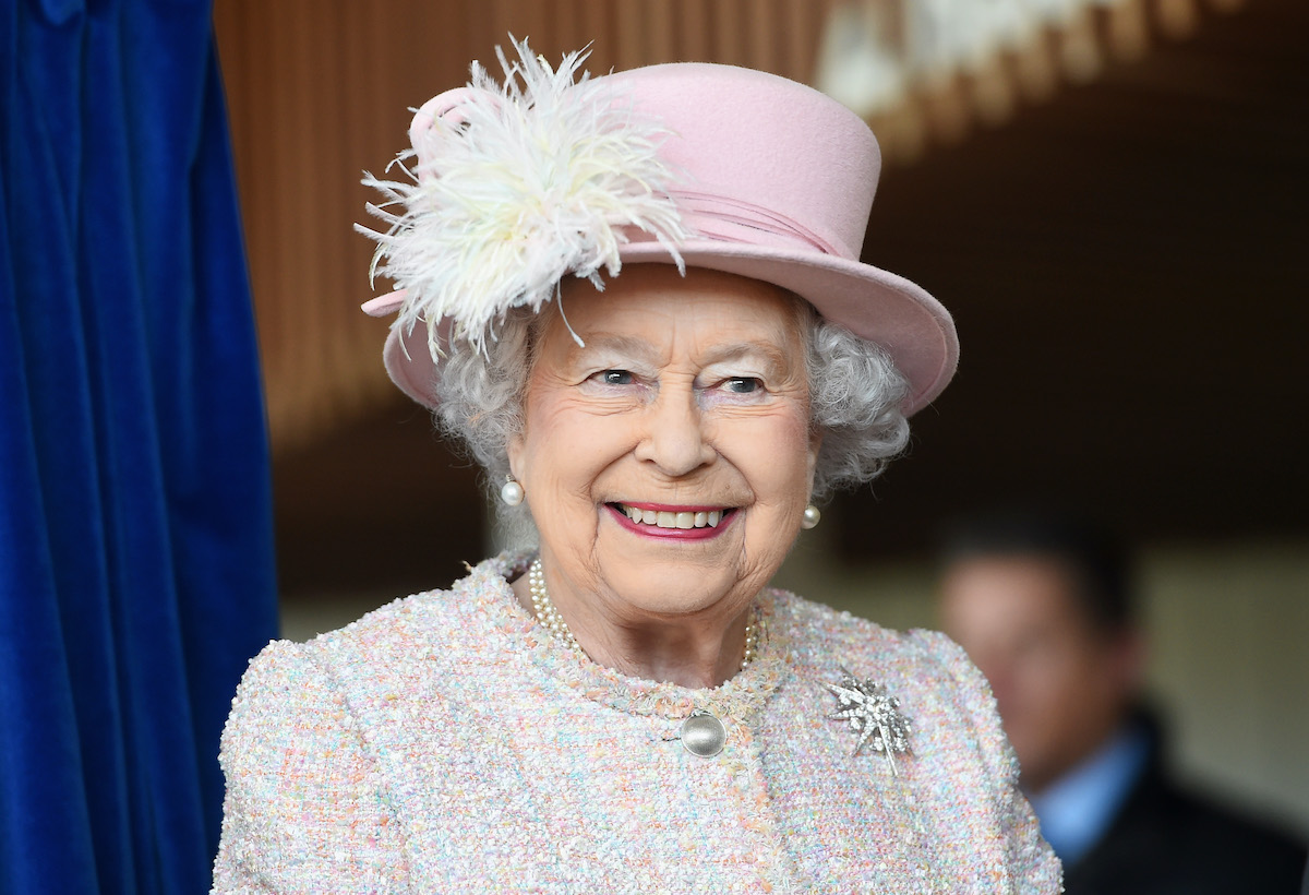 伊丽莎白二世女王戴着浅粉色的帽子和上衣