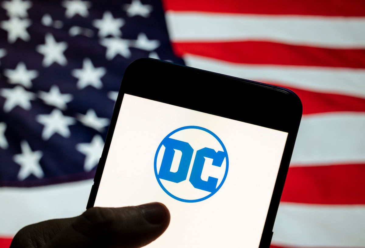 以美国国旗为背景的智能手机上显示的DC漫画标志