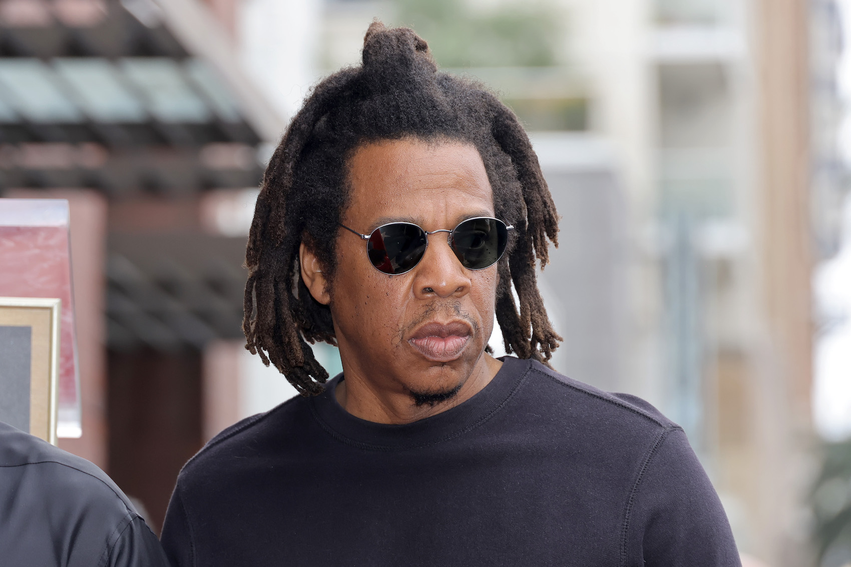 Jay-Z身穿黑色t恤，戴着墨镜，与他几张大牌专辑封面的摄影师打官司