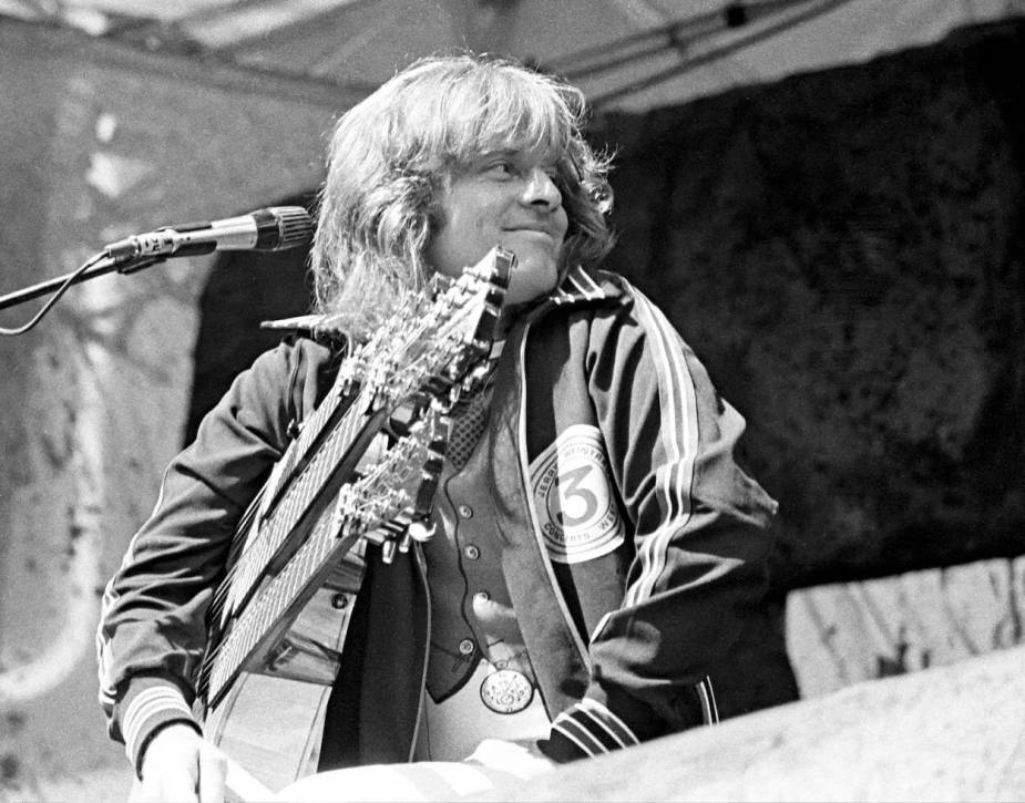 1977年，齐柏林飞艇乐队的约翰·保罗·琼斯在加州奥克兰的一场音乐会上微笑着回头看。