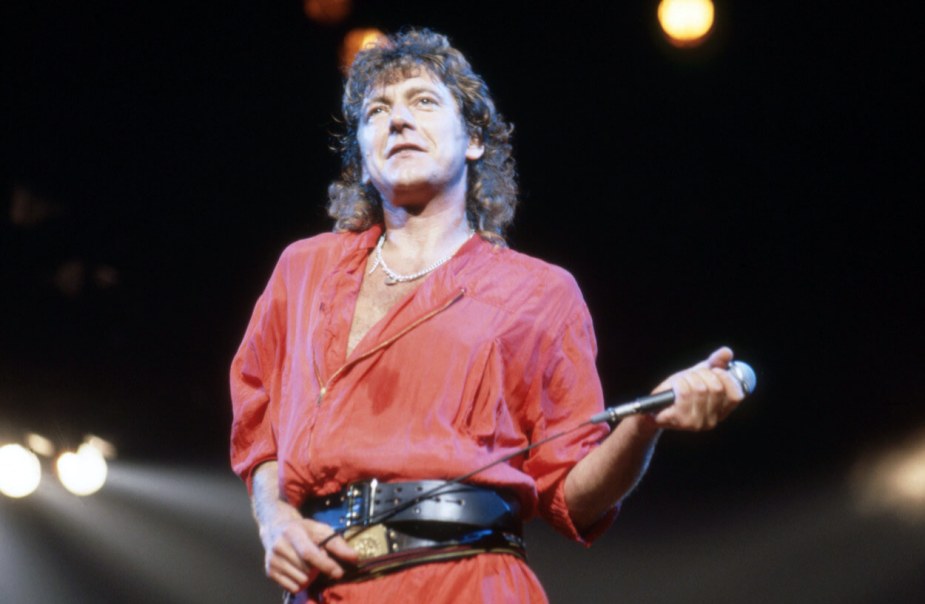 1983年，齐柏林飞艇乐队主唱罗伯特·普兰特在底特律的一场音乐会上身穿红色衬衫，手持麦克风。